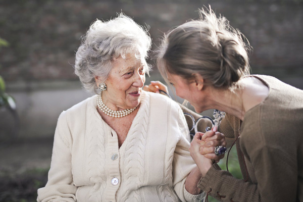 Junge Frau spricht liebevoll mit einer Seniorin (Bildquelle: Pexels)