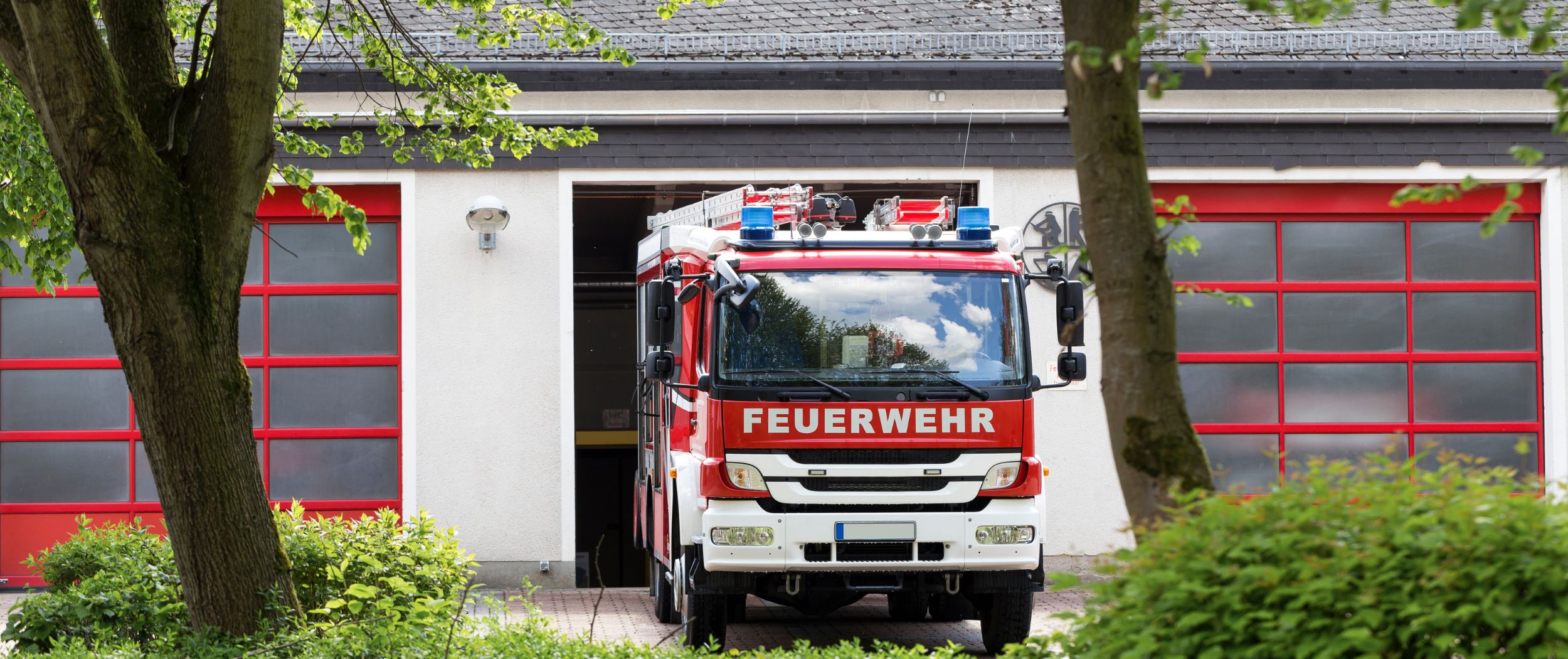 Ein Feuerwehrauto fährt aus einer Fahrzeughalle