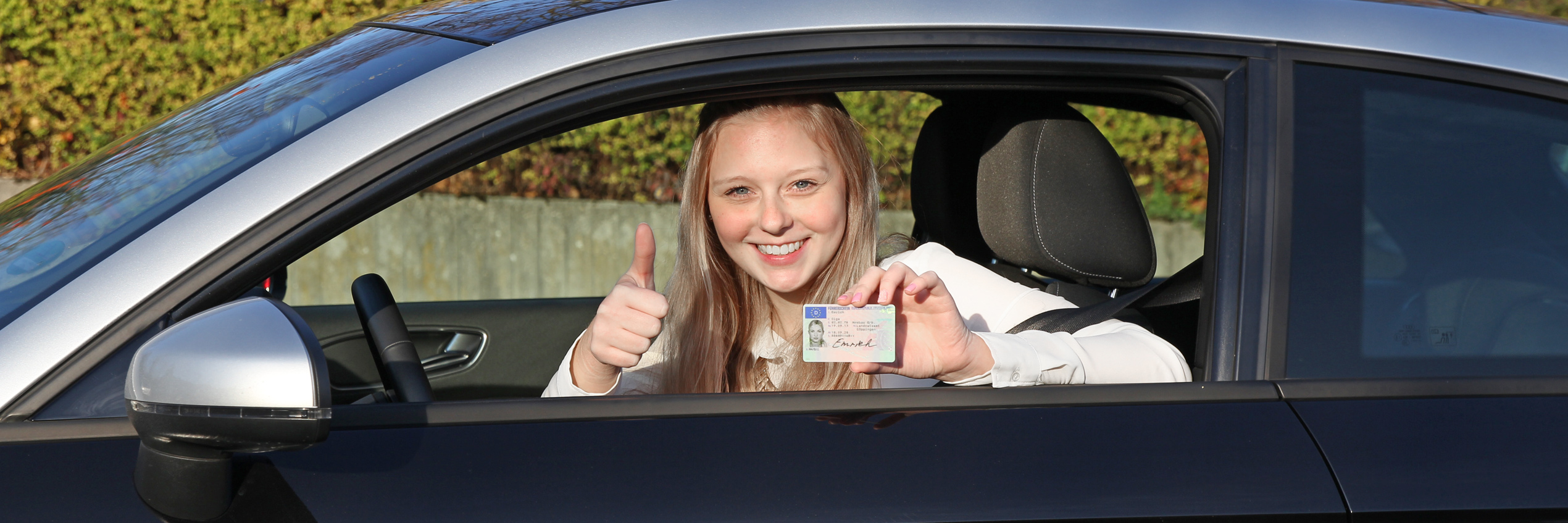 Junge Frau zeigt ihrem Kartenführerschein